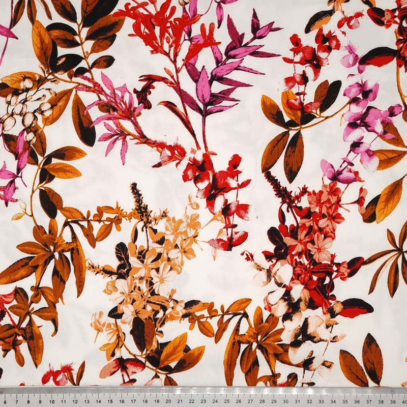 A red floral pattern with golden summer leaves printed on a cotton sateen fabric with a cm ruler