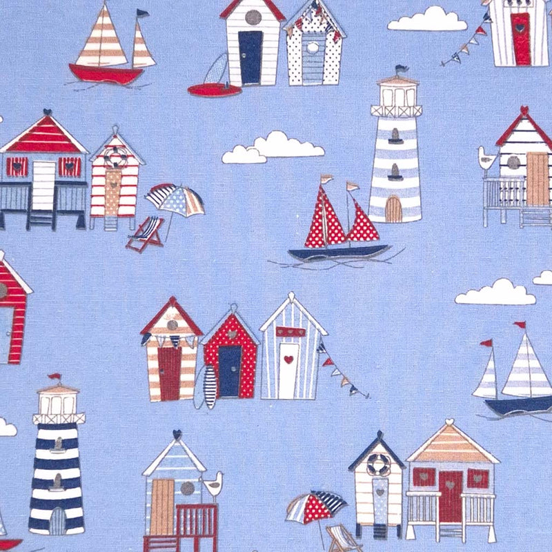 White, red and navy beach huts digitally printed on a blue cotton rich, half panama, linen look craft canvas fabric.