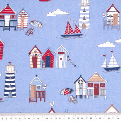 White, red and navy beach huts digitally printed on a blue cotton rich, half panama, linen look craft canvas fabric with a cm ruler.