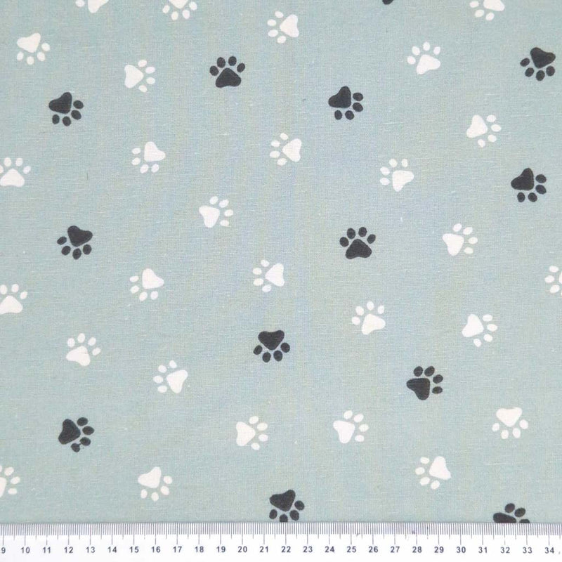 Paw prints printed on a duck egg cotton canvas fabric with a cm ruler