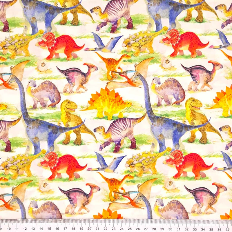 Colourful dinosaurs are printed on an ivory cotton poplin fabric with a cm ruler