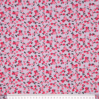 Floral pattern with pink flowers on a light gray viscose fabric with a ruler