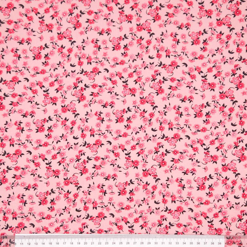 Pink fabric with small floral pattern on a viscose fabric with a ruler