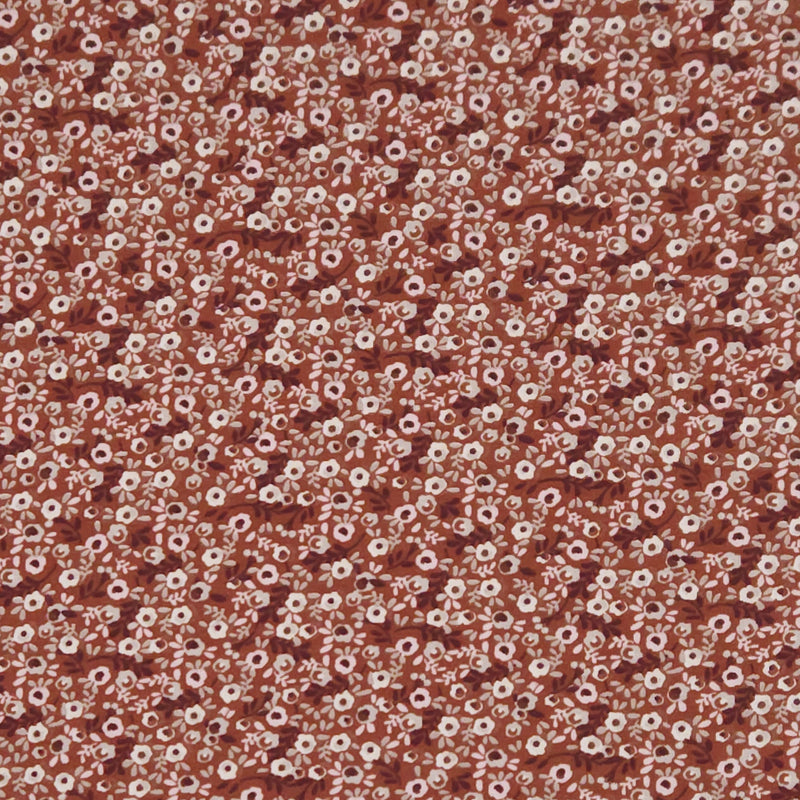 Ditsy flowers printed on a brown cotton jersey fabric