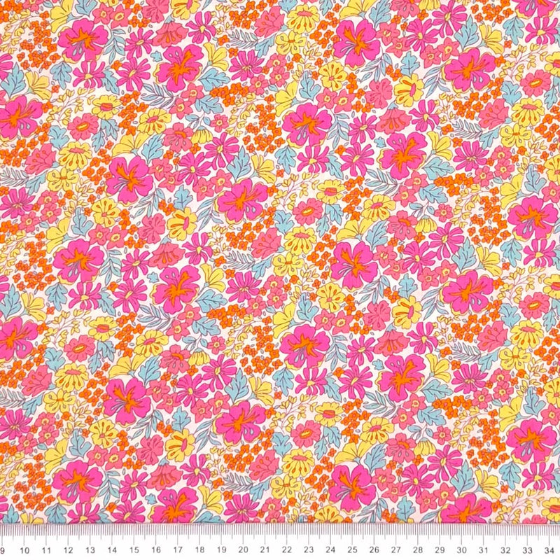 Pink and yellow ditsy flowers are printed on a cotton lawn fabric with a cm ruler