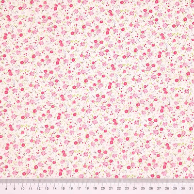 Ditsy floral pattern with pink flowers on a cream background with a cm ruler