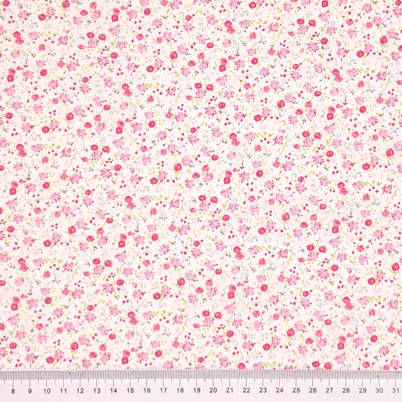 Ditsy floral pattern with pink flowers on a cream background with a cm ruler