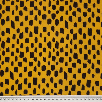 Black blocks printed on a mustard coloured double gauze with a cm ruler