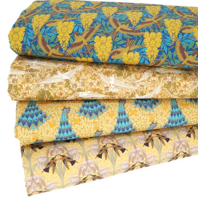 A fat quarter bundle of 4 art prints on a cotton percale fabric in gold and blue