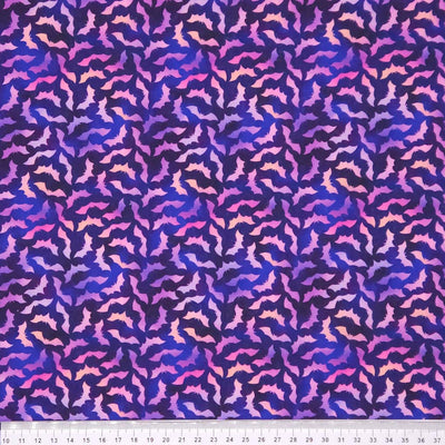 Patterned cotton halloween fabric with purple and pink bat design with a cm ruler