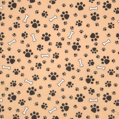 Dog paws and bones printed on a camel coloured polycotton fabric