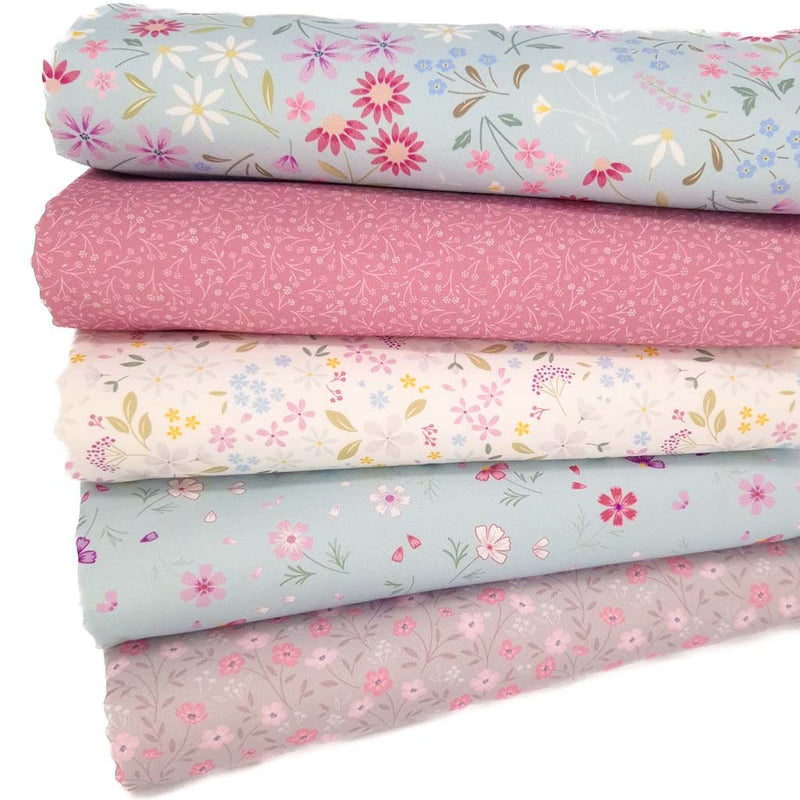 A fat quarter bundle with pressed flowers in light teal printed on cotton quilting fabric by Lewis & Irene