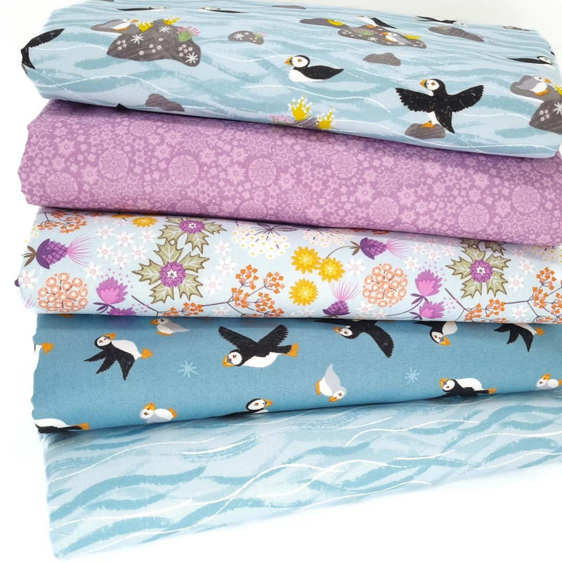 A fat quarter bundle of five puffin themed quilting fabric by Lewis & Irene