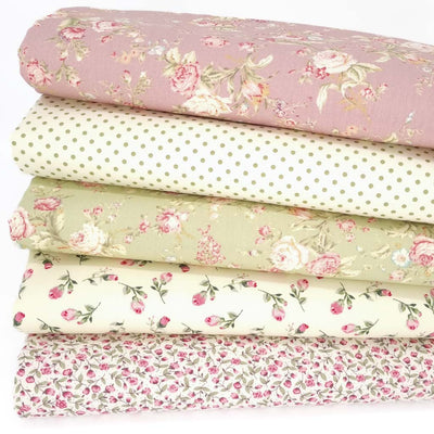 Five floral cotton fabrics in a bundle with a rose coloured design on top, a spot, a green rose and two ditsy designs