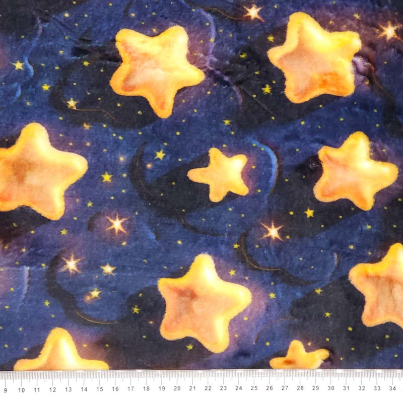 Pattern of yellow stars on a dark blue cuddle fleece fabric with a cm ruler