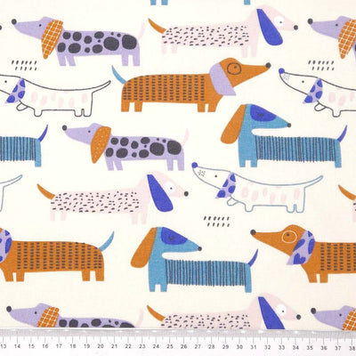 Pattern of colourful dachshunds on an ivory canvas fabric with a cm ruler