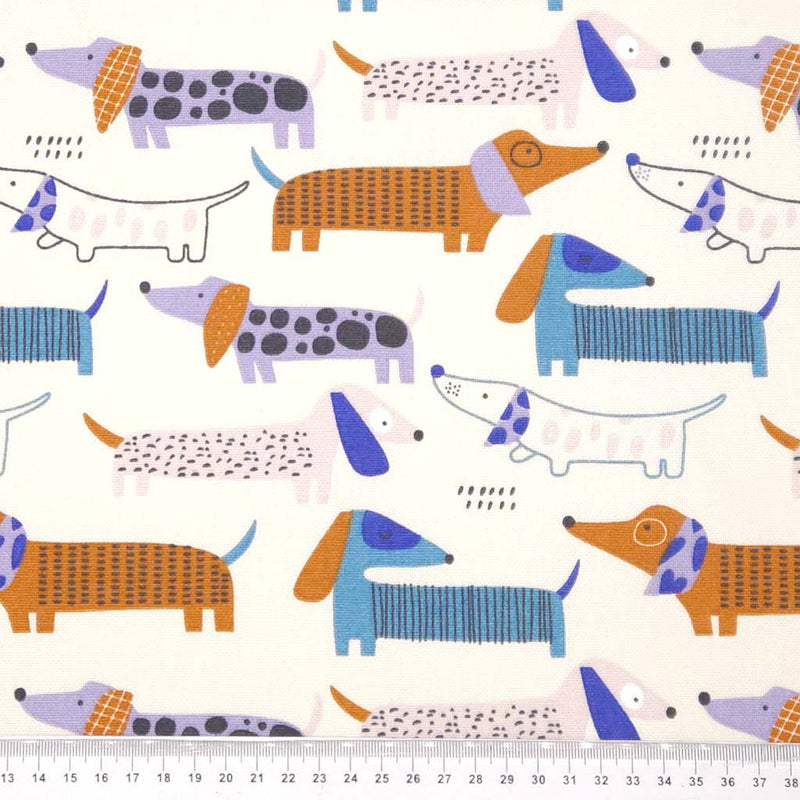 Pattern of colourful dachshunds on an ivory canvas fabric with a cm ruler