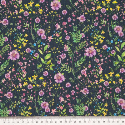 Floral design printed on a black cotton needlecord fabric with a cm ruler