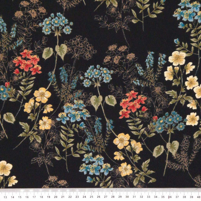 Wild flowers are printed on a black viscose fabric with a cm ruler