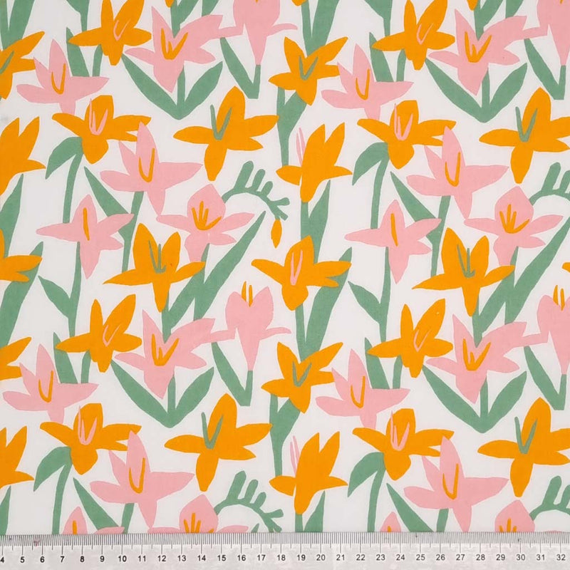Pink and orange Lily flowers are printed on a white polycotton fabric with a cm ruler