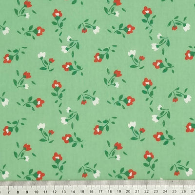 Pink and white tulip flowers are printed on a sage polycotton fabric with a cm ruler