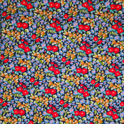 Navy blue pima cotton lawn fabric with a small floral pattern featuring red, orange, and blue flowers.