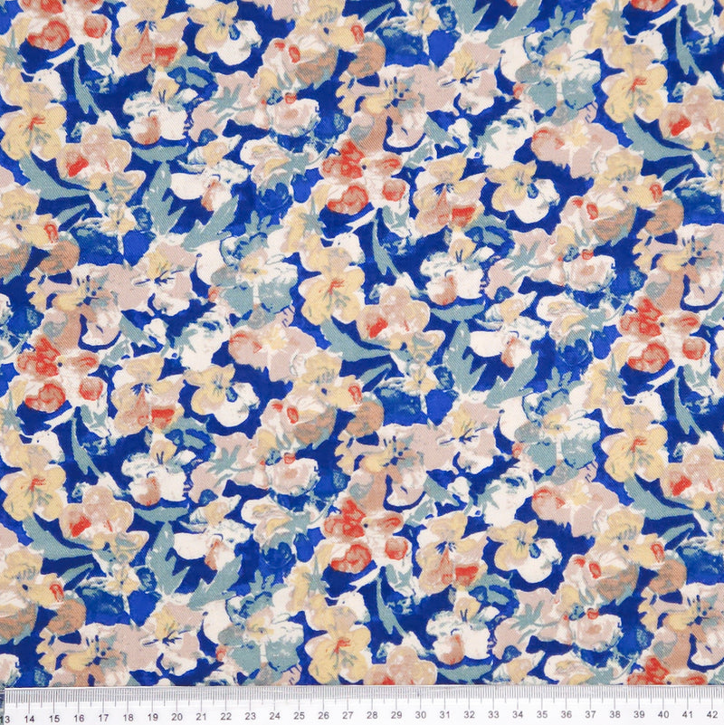 Floral pattern with small flowers in red, white, and blue on a blue viscose fabric with a cm ruler