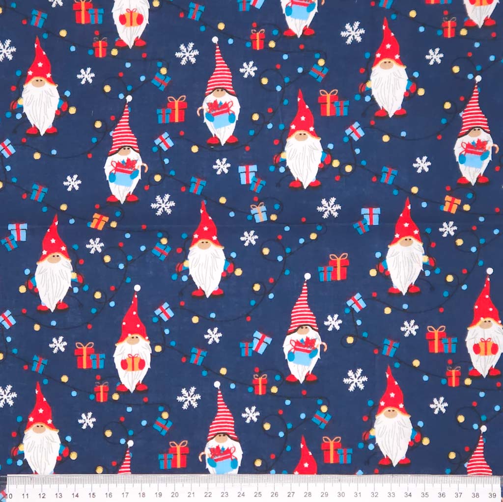Pattern of Christmas gnomes, presents, and snowflakes on a blue cotton fabric with a ruler
