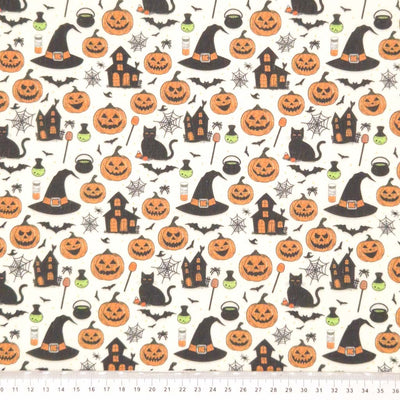 Halloween-themed fabric pattern with pumpkins, cats, witches' hats, and ghosts on a cream polycotton.