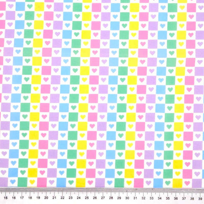 Pattern of pastel-colored squares and hearts on a white polycotton fabric