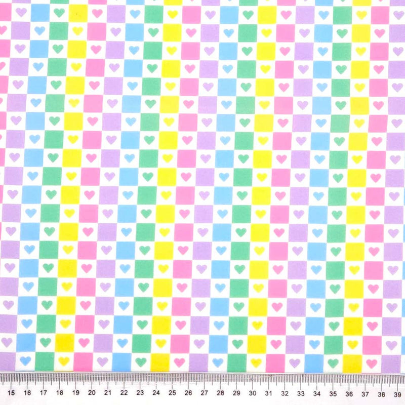 Pattern of pastel-colored squares and hearts on a white polycotton fabric
