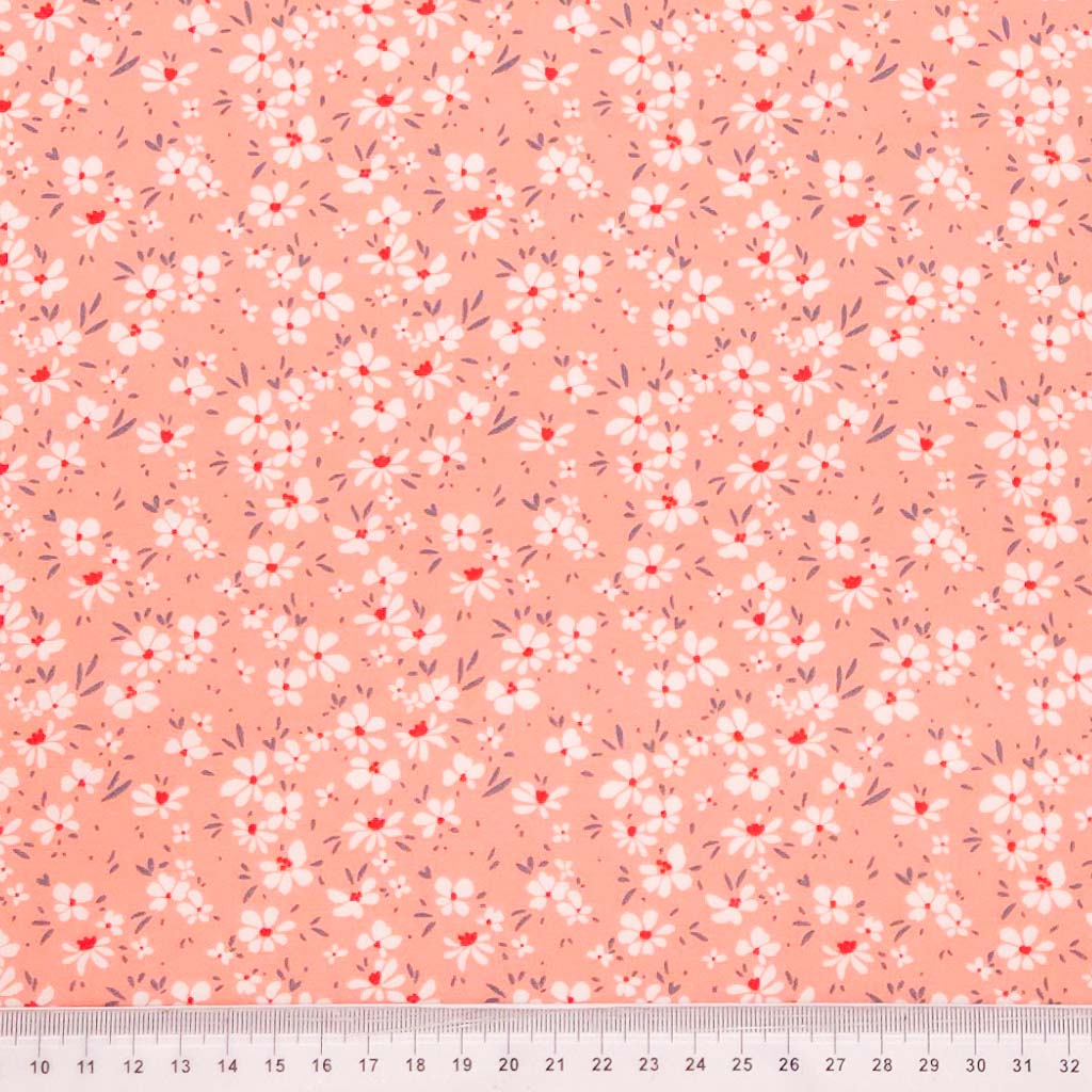 Ditsy floral on pink cotton poplin fabric with a cm ruler