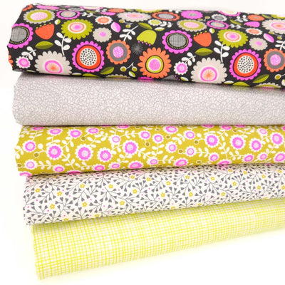 Stack of colorful floral and checkered fabrics on a white background