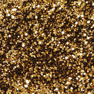 Close-up of gold glitter on a black velvet fabric
