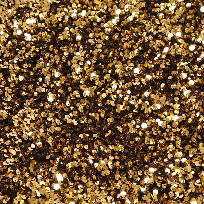 Close-up of gold glitter on a black velvet fabric