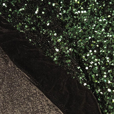 Close-up of a textured black fabric with a green sequined background