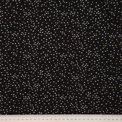 Black fabric with small white polka dots and a ruler at the bottom for scale.