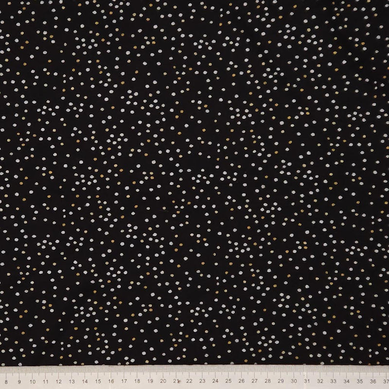 Black fabric with small white polka dots and a ruler at the bottom for scale.