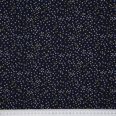 Navy blue fabric with small multicolored dots, measured against a white ruler at the bottom.