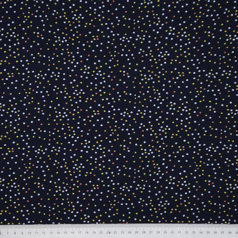 Navy blue fabric with small multicolored dots, measured against a white ruler at the bottom.