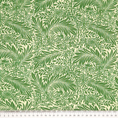 Sage green larkspur leaves printed on a cream cotton fabric with a cm ruler