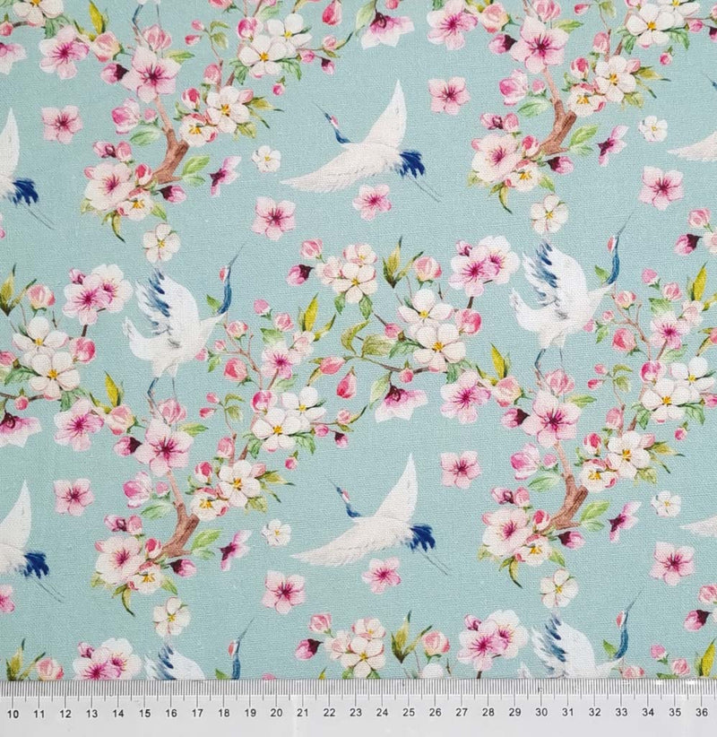 Birds and pink blossom printed on a pale aqua linen fabric with a cm ruler