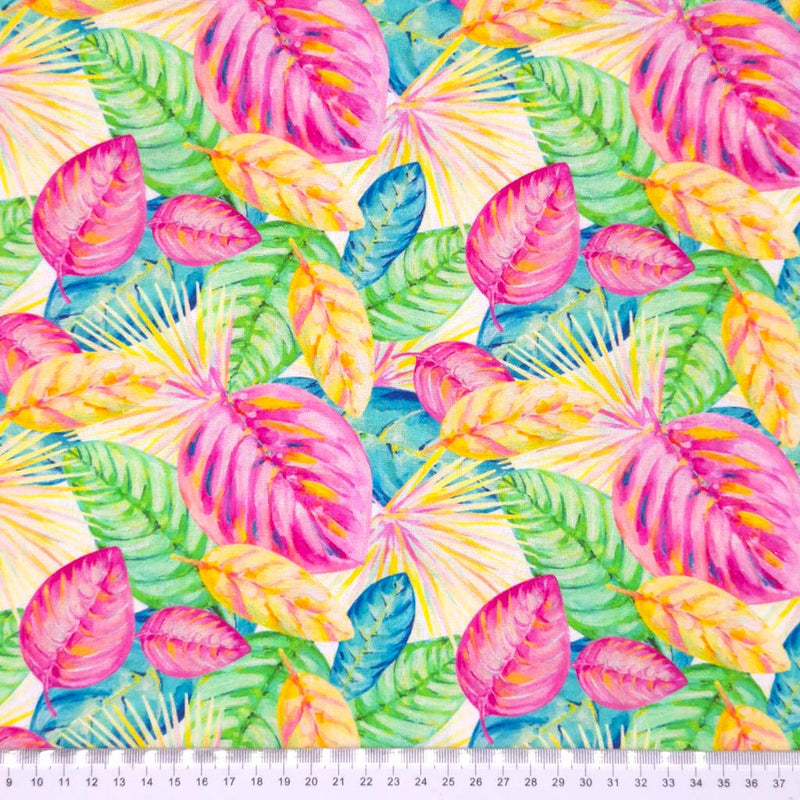 Detailed fan leaves in vibrant summer shades of pink, yellow, green and blue printed on a butter yellow linen mix dressmaking fabric with a cm ruler.