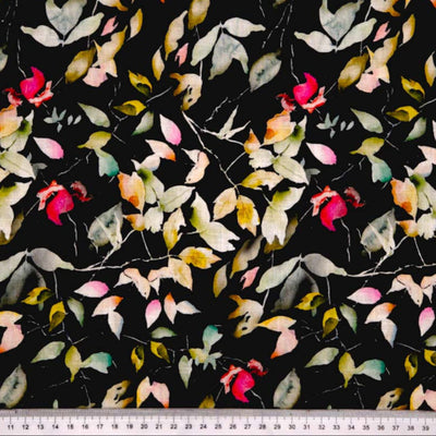 Pattern of colourful leaves on a textured black linen fabric with a cm ruler