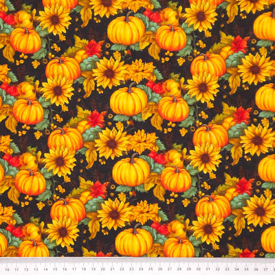 Fabric with pumpkins and sunflowers pattern on a dark cotton fabric with a cm ruler