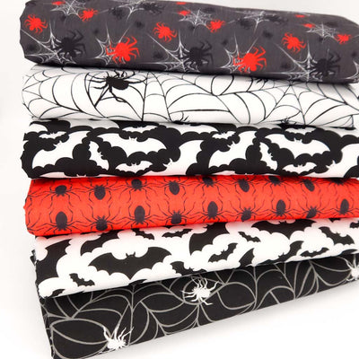 A halloween themed fat quarter bundle with spiders and bats in black, red and white