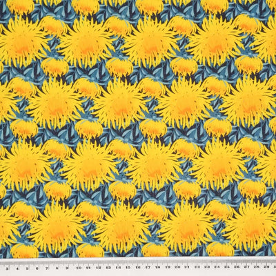 Bright yellow chrysanthemum flowers printed on a blue needlecord fabric with a cm ruler