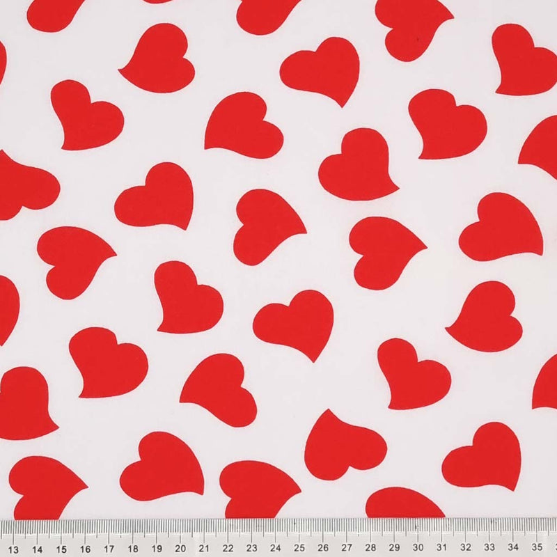Red love hearts are printed on a plain white, quality polycotton fabric with a cm ruler