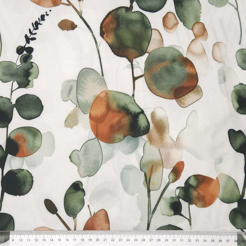 Floral pattern with green, orange, and beige leaves on a white viscose twill fabric