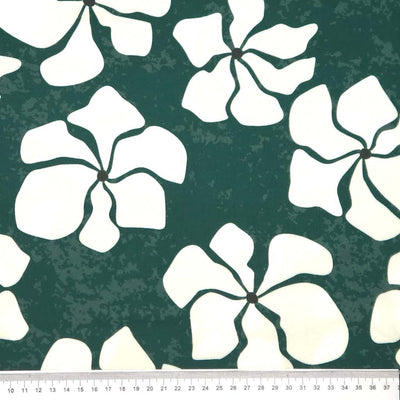 White floral patterns on a green textured viscose twill fabric with a ruler at the bottom.